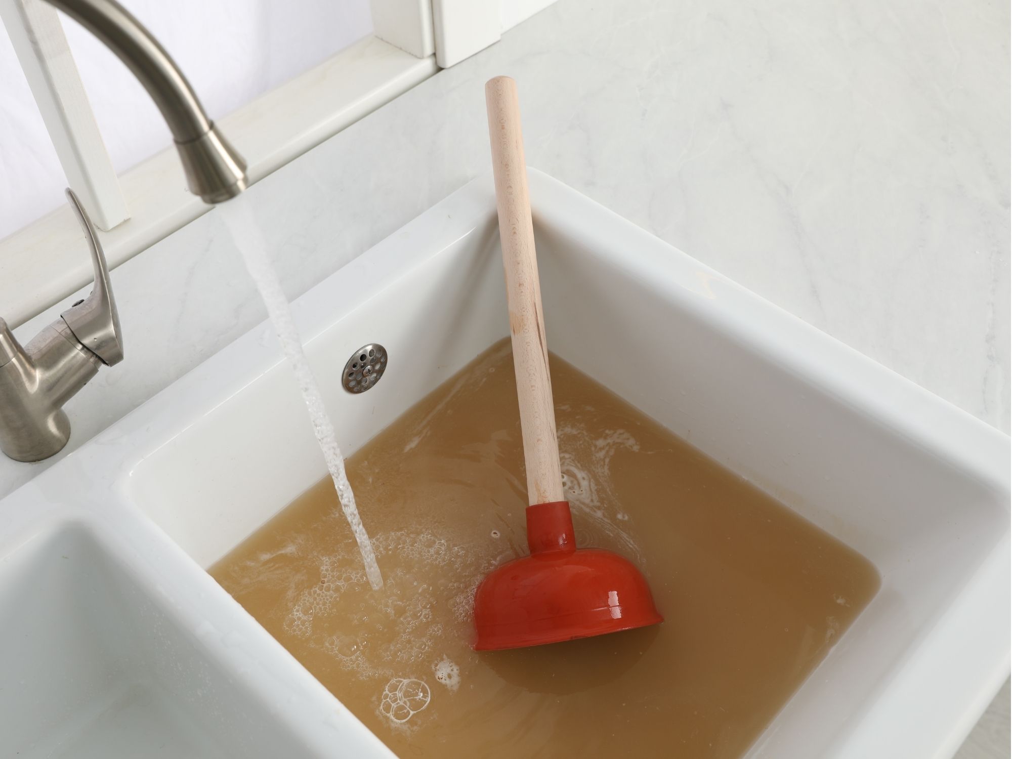 Plumber clearing a clogged sink